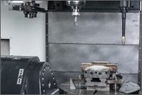 Obr. 2: Pracovní prostor stroje WeldPrint 5AX s výměníkem nástrojů, pracovním vřetenem a navařovací hlavou