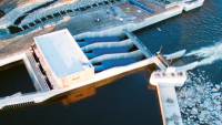 Foto z dronu zobrazuje v horní části řešení rybího schodiště vedle strojovny MVe Planá a betonový jez s propustí