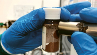 Magnet přitahuje materiál, který tým použil k výrobě adsorbentů, jež odstraňují mikroplasty a rozpuštěné znečišťující látky z vody © RMIT University