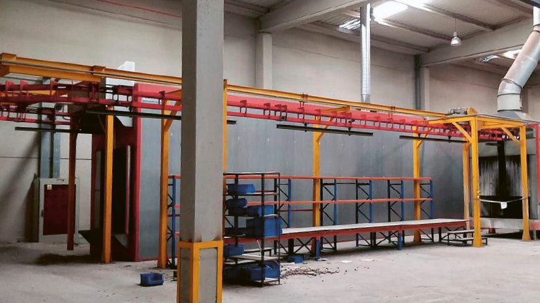 Obrobky jsou zavěšeny na transportní kolejnici a procházejí celým zařízením, od nanášení až po pec © Surplex