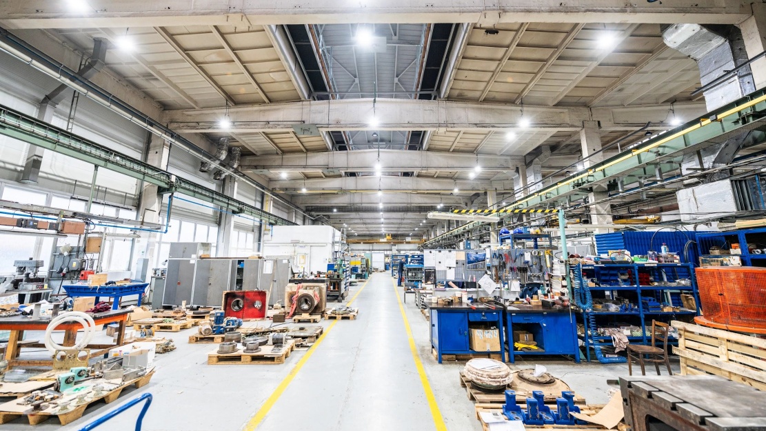 Moderní průmyslová hala s rovnoměrně rozloženým LED osvětlením typu high-bay. Ukázka energeticky efektivního provozu.