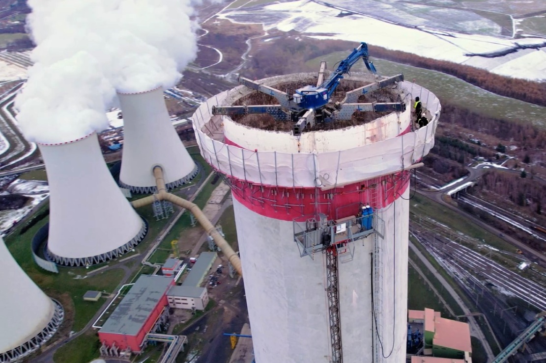 V koruně komína byl usazen demoliční bagr - začátek září