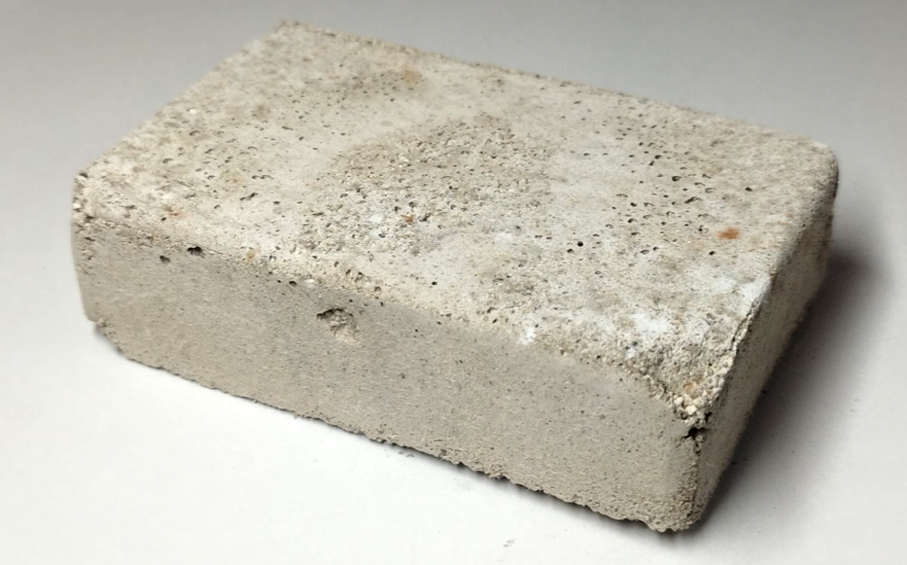 Zkušební vzorek z odpadního betonového prachu, který stmelily látky vytvořené bakterií Sutcliffiella cohnii Zkušební vzorek z odpadního betonového prachu, který stmelily látky vytvořené bakterií Sutcliffiella cohnii